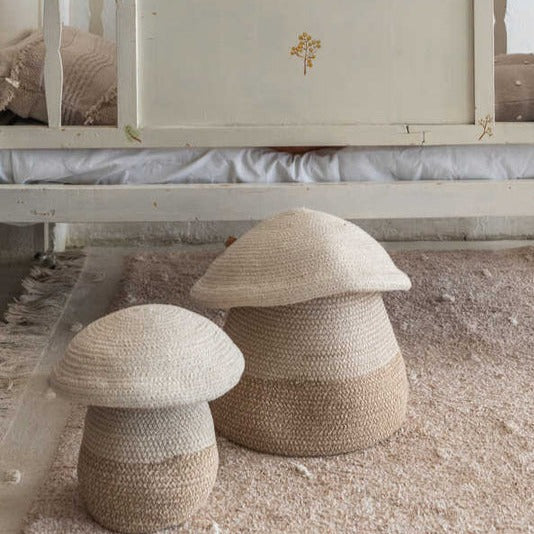 Lorena canals mushroom baskets in both sizes sitting on a rug next to a toddler bed.